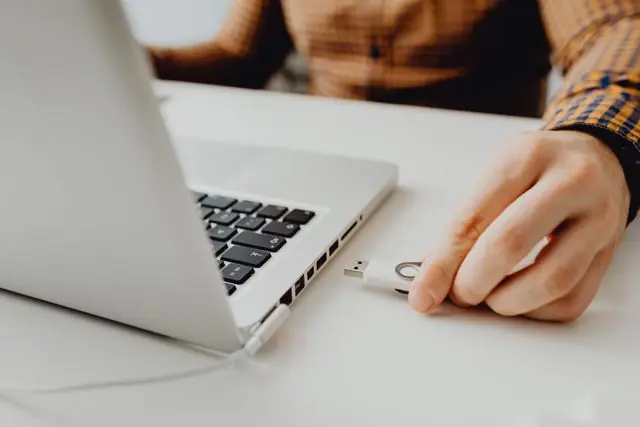 Persona conectando memoria USB a computadora para carga inicial de datos en el sistema